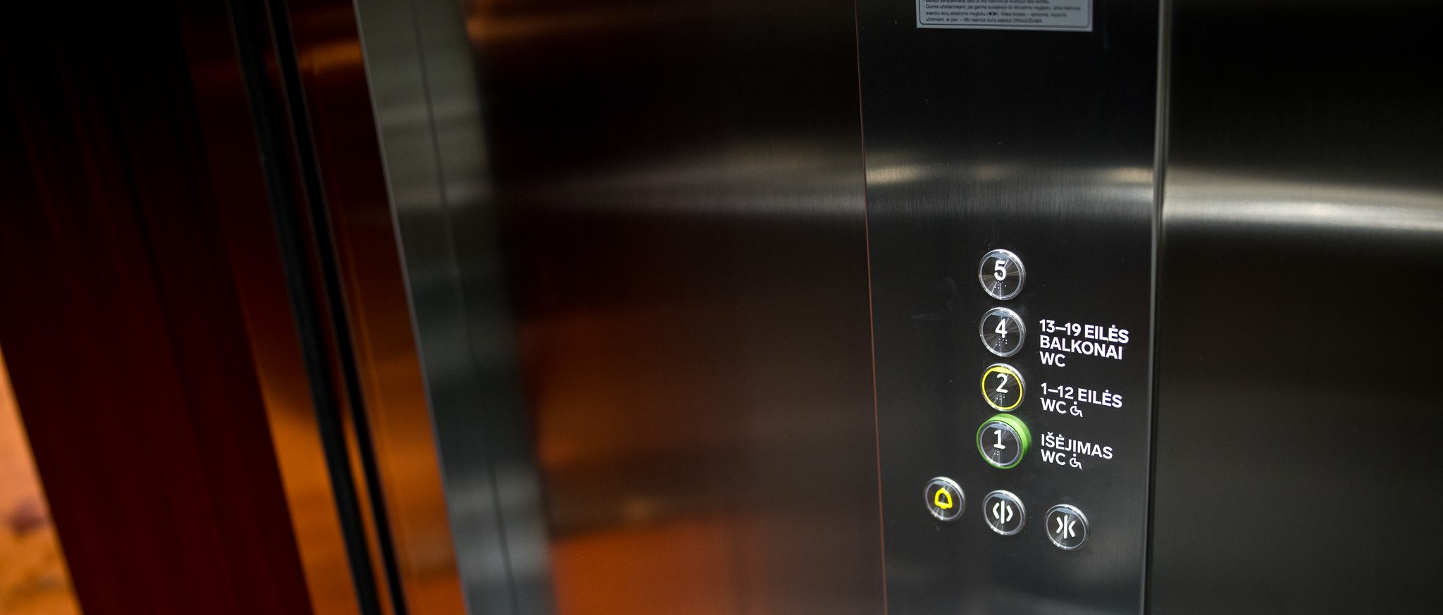 apie mus skiltyje - orona liftas iš Operos namų Vilniuje